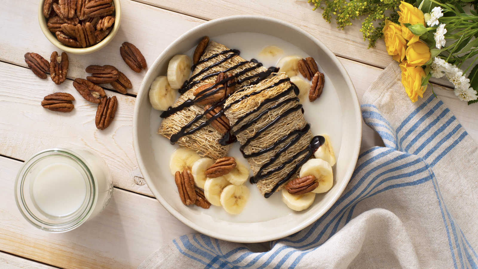 Shredded Wheat Go Bananas breakfast bowl with pecans and banana slices on top.